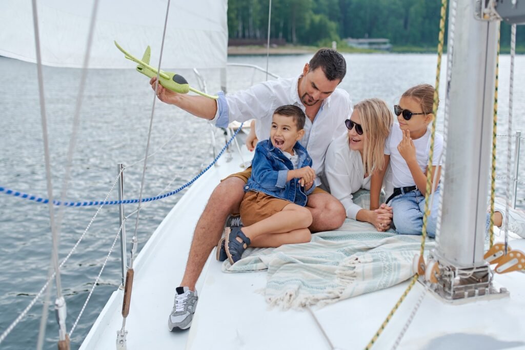 Full body of family in summer clothes having fun together on yacht in summer day