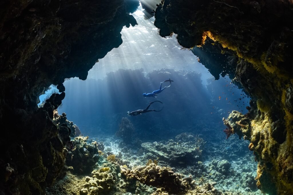 a scuba diver swims through an underwater cave having the best time to visit Phuket Island